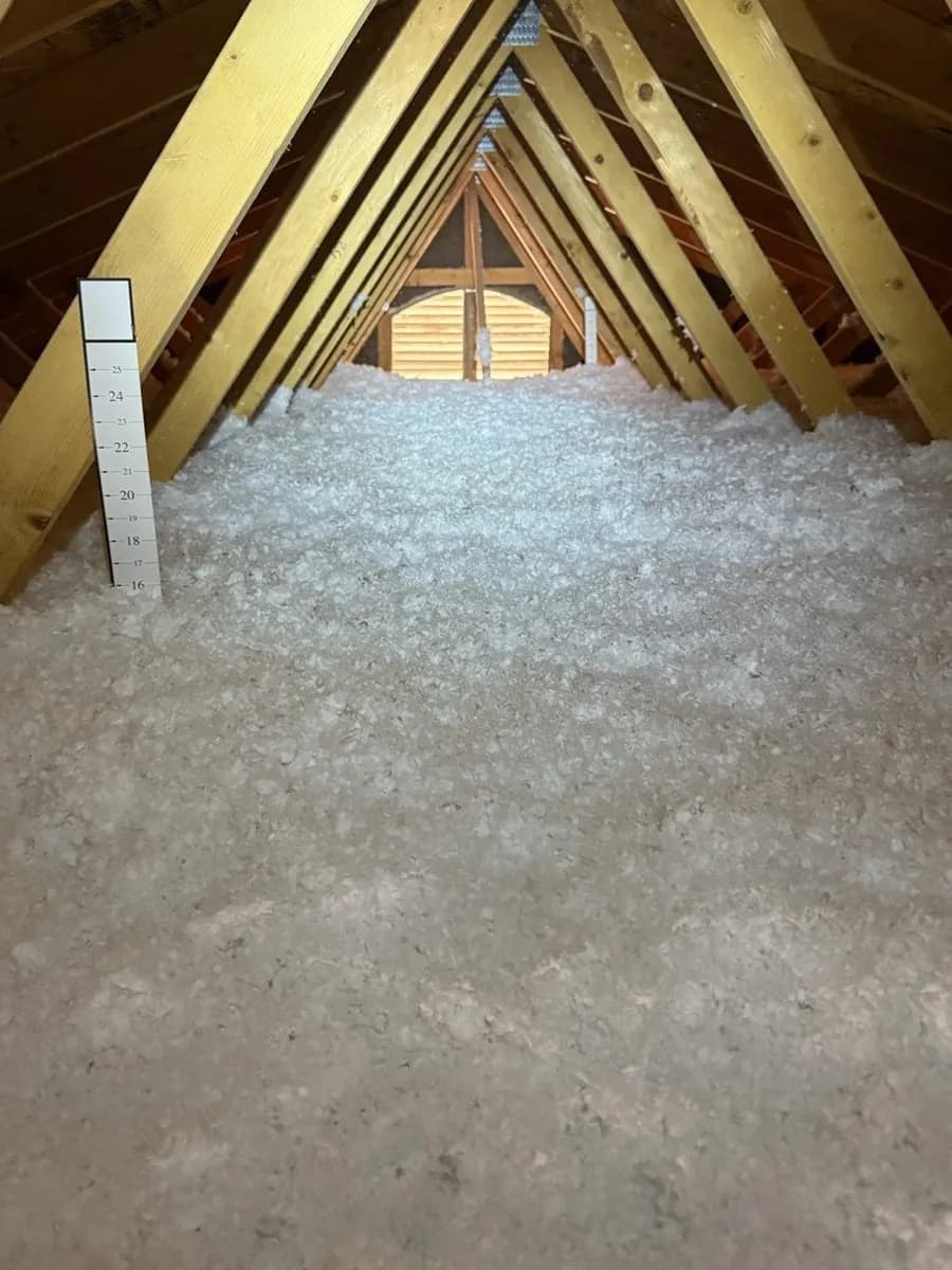 Same attic after Arizona Attic Pros blown-in InsulSafe fiberglass installation, depth ruler showing over 16 inches